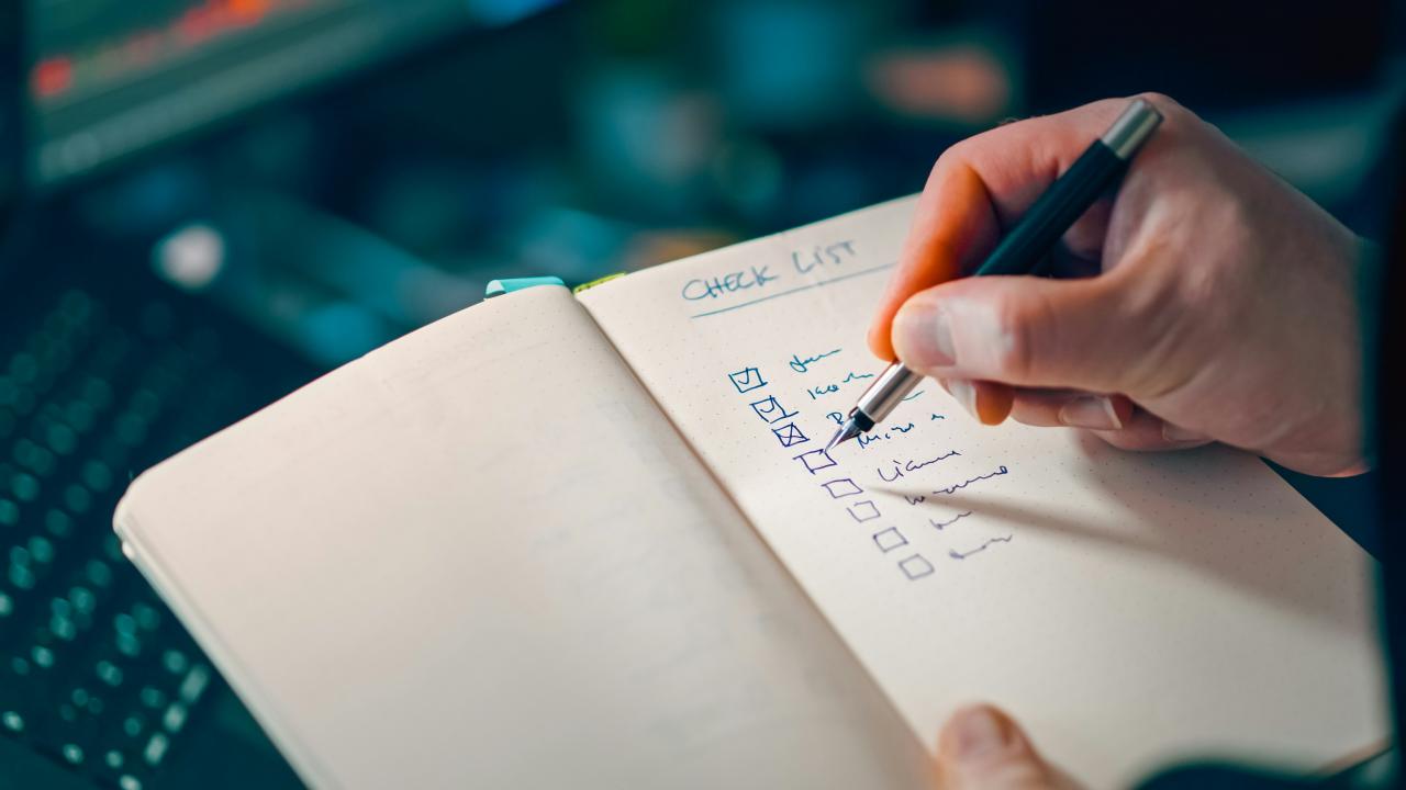 Menulis daftar periksa dengan tangan di buku catatan