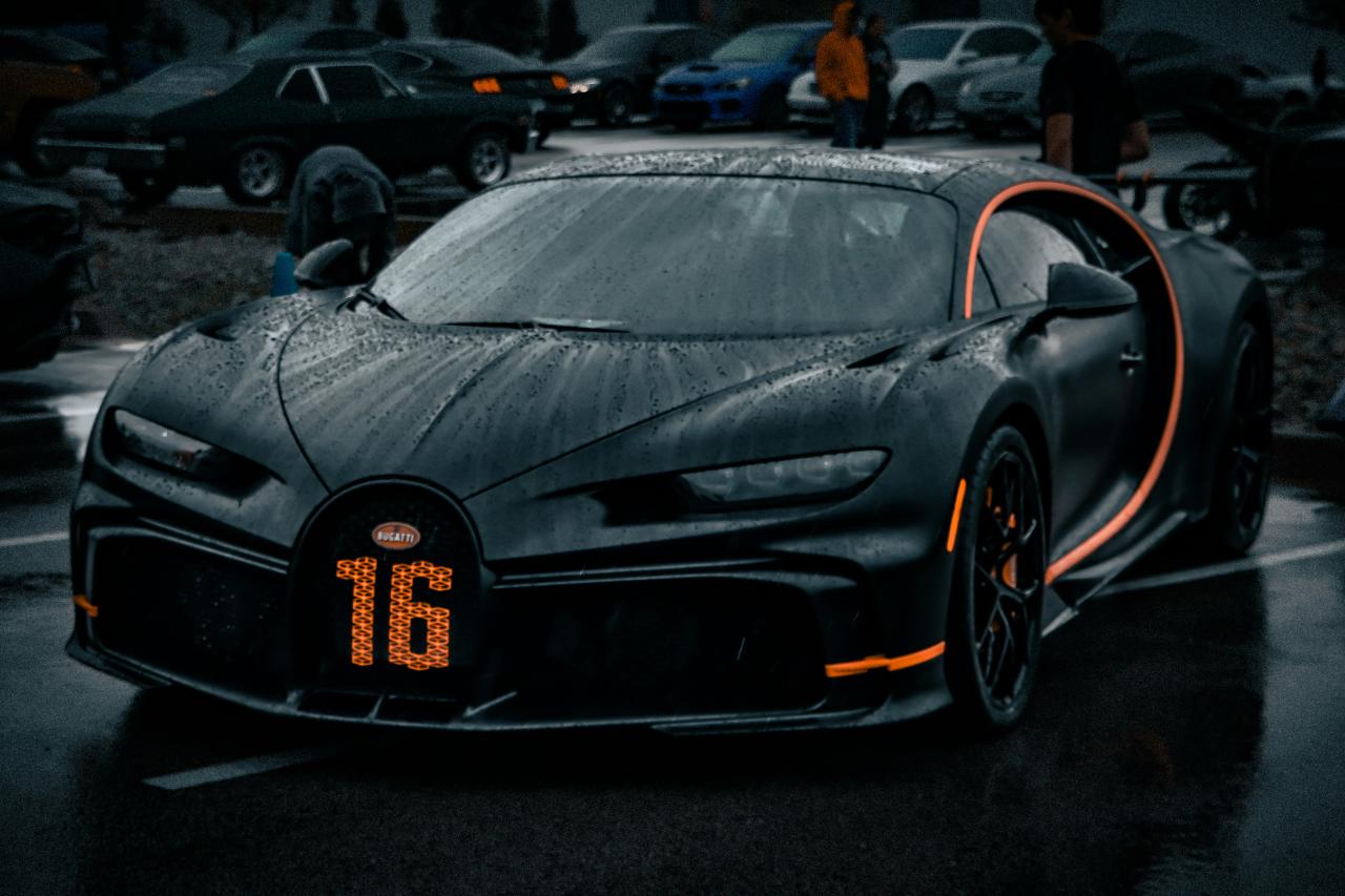 A black bugatti chiron with orange accents and number 16.